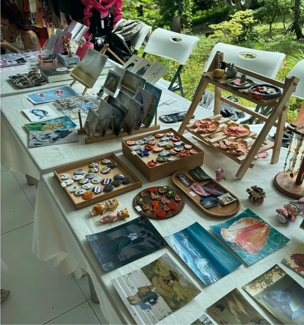Arts and crafts booth with handmade items and framed work on display