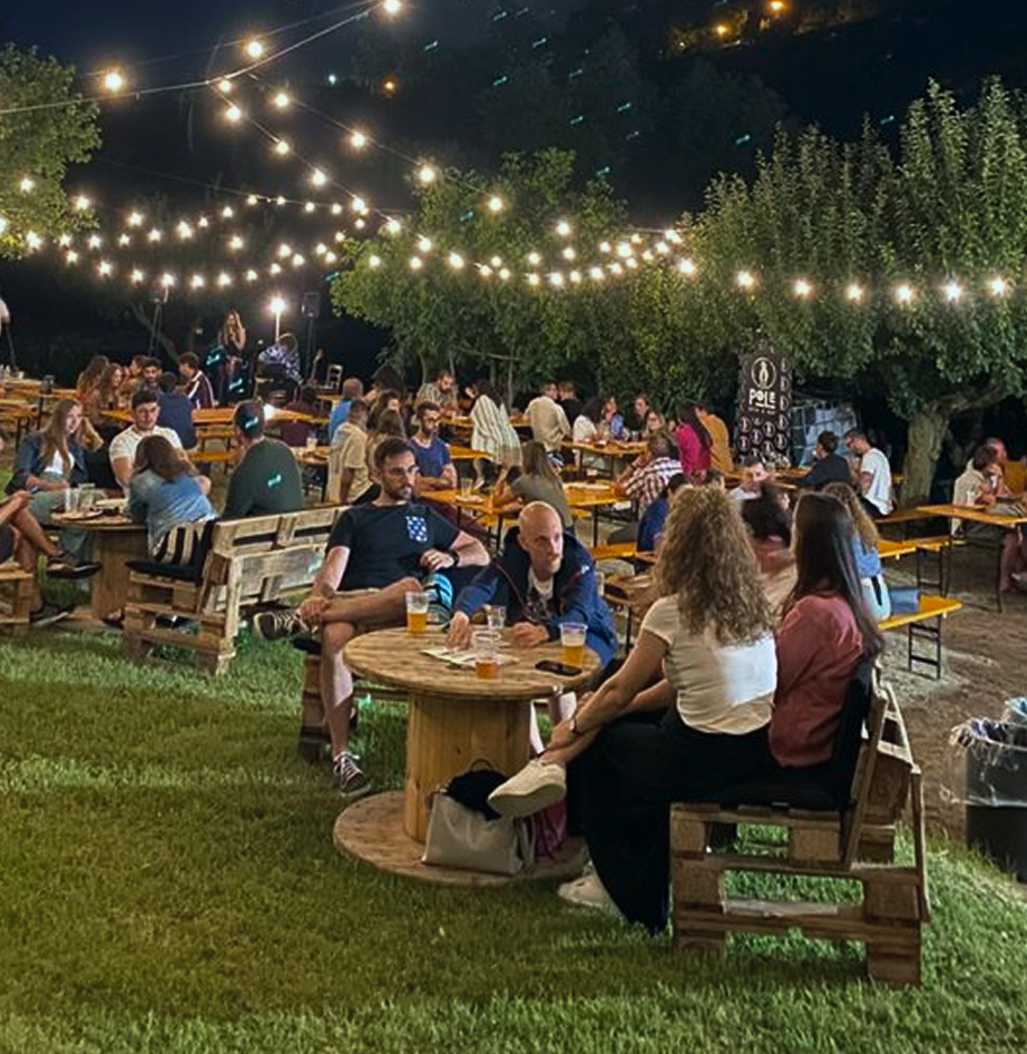 Outdoor beer garden at the festival with people seated under string lights
