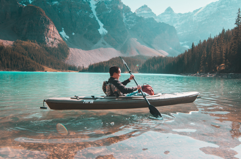 person in a canoeing in the middle of a lake