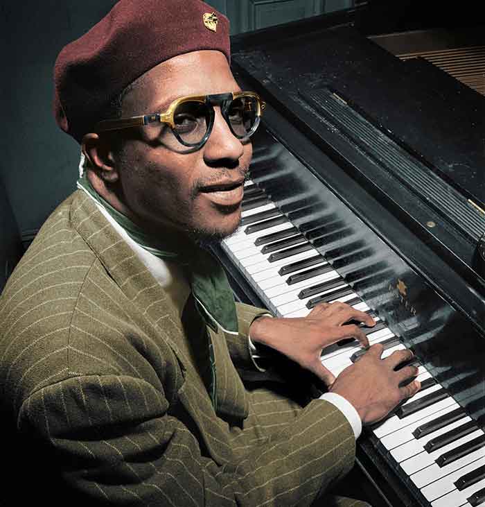 A side view of Theolonious Monk playing the piano
