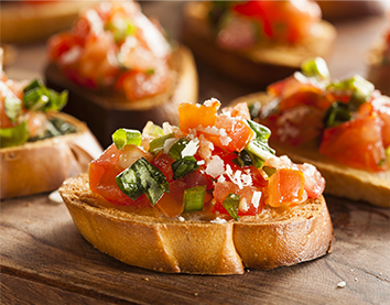 Sliced bread pieces with tomato and other toppings.