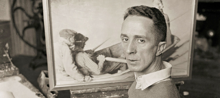 Artists Norman Rockwell facing the camera in his stuio with a canvas behind him.