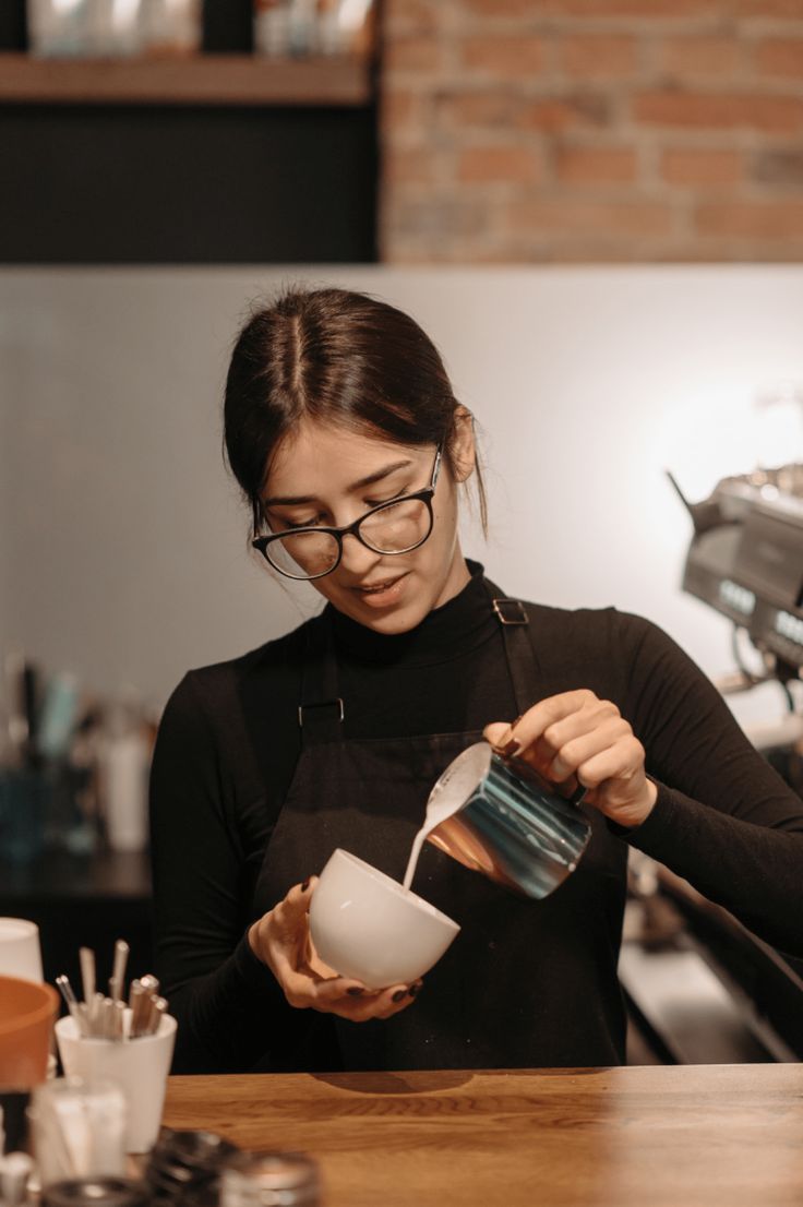 barista pouring cream into a latte