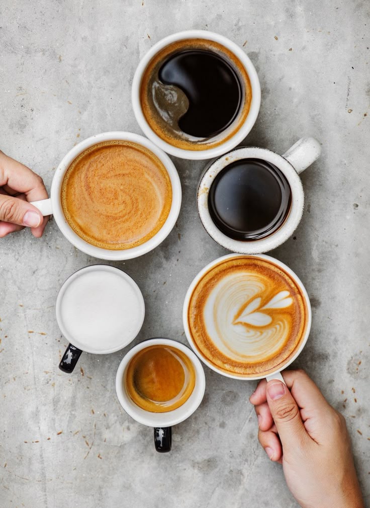 latte art in a white mug on a brown wooden table