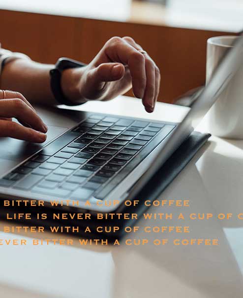 person typing on computer with a cup of coffee